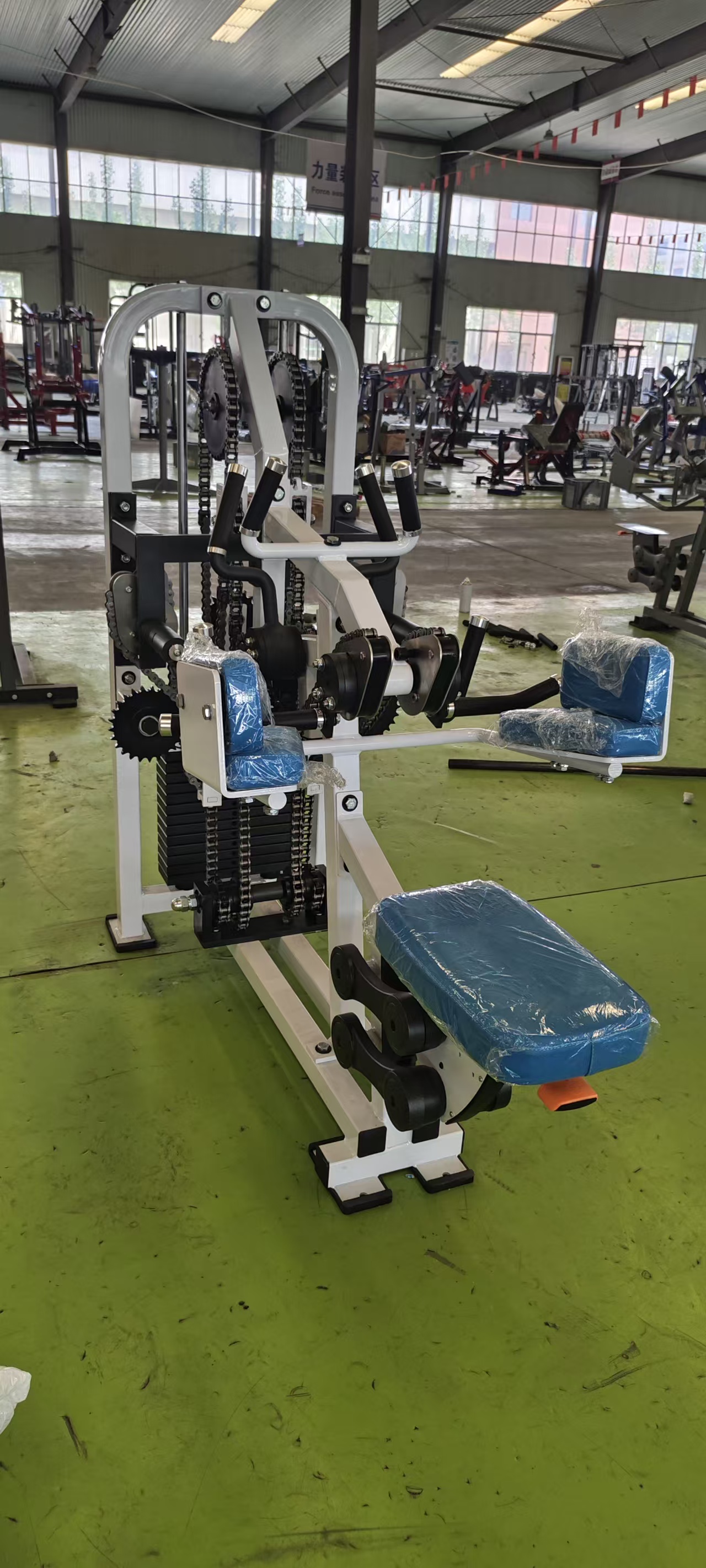 Commercial forearm grip trainer showing seated user position and chain transmission